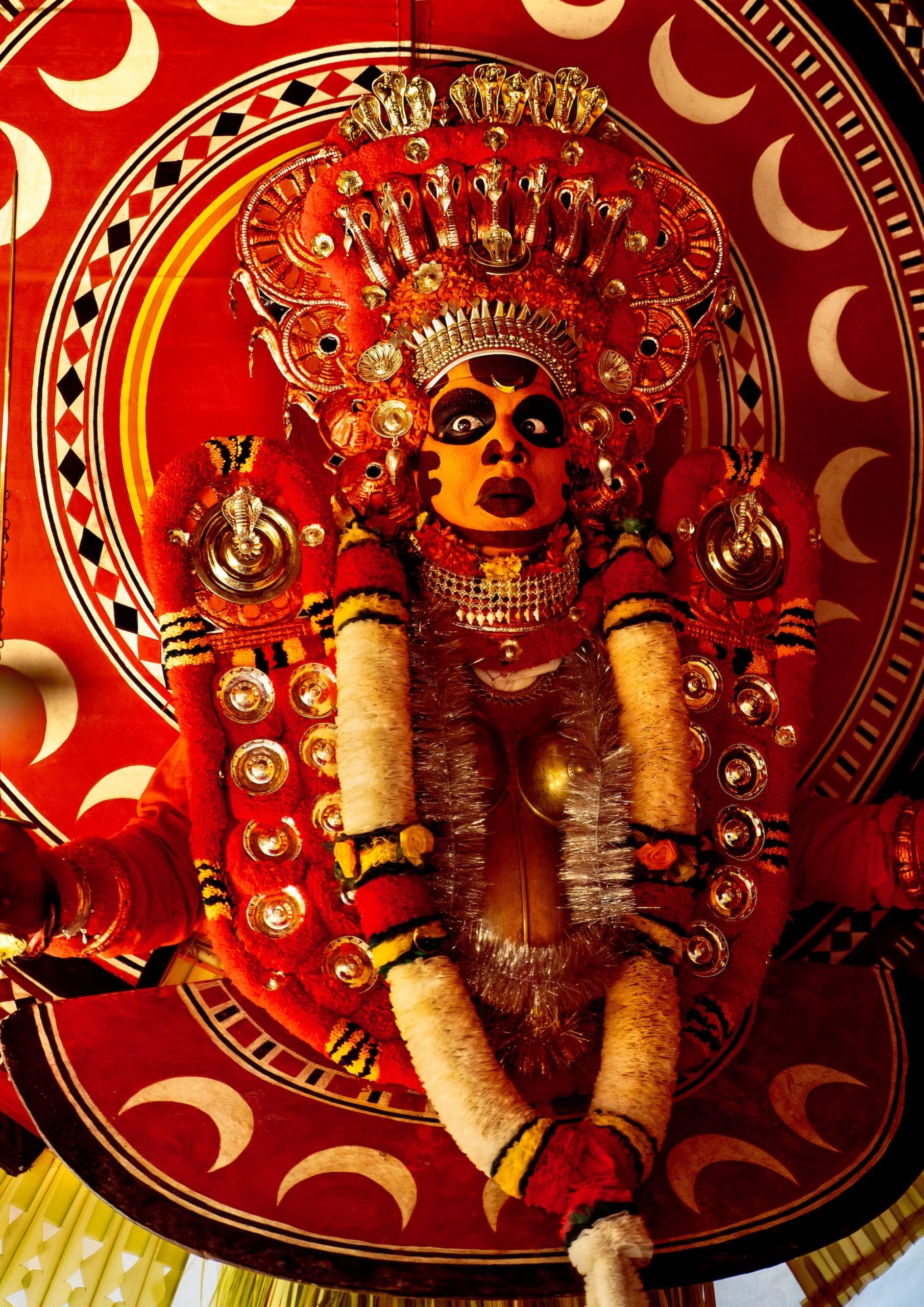 a photograph by Navneet Jayakumar of an elaborate ceremonial outfit worn by a performer for Theyyam, in Kerala, India